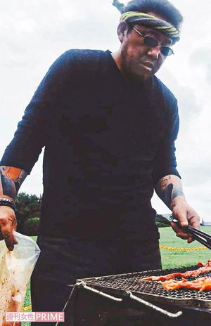 靖雄容疑者とみられる人物。肉を焼く腕には入れ墨（会社のフェイスブックより）