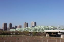 JR東北線・京浜東北線の荒川橋梁。橋の手前、東京側は北区赤羽。向こう側のタワーマンションが並び立つ地が埼玉県の川口だ（筆者撮影）