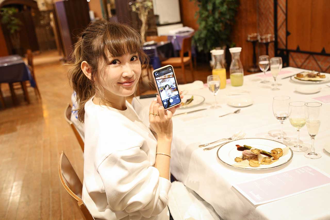 スマホで撮影したYOSHIの画像を見せる紗栄子（『YOUR RESTAURANT』プレスリリースより）