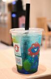 物議を醸したエスタシオンカフェの『ミャクミャクフルーツソーダ』。本来は真っ赤なチェリーが浮かんでいるはずが……。(Xより)