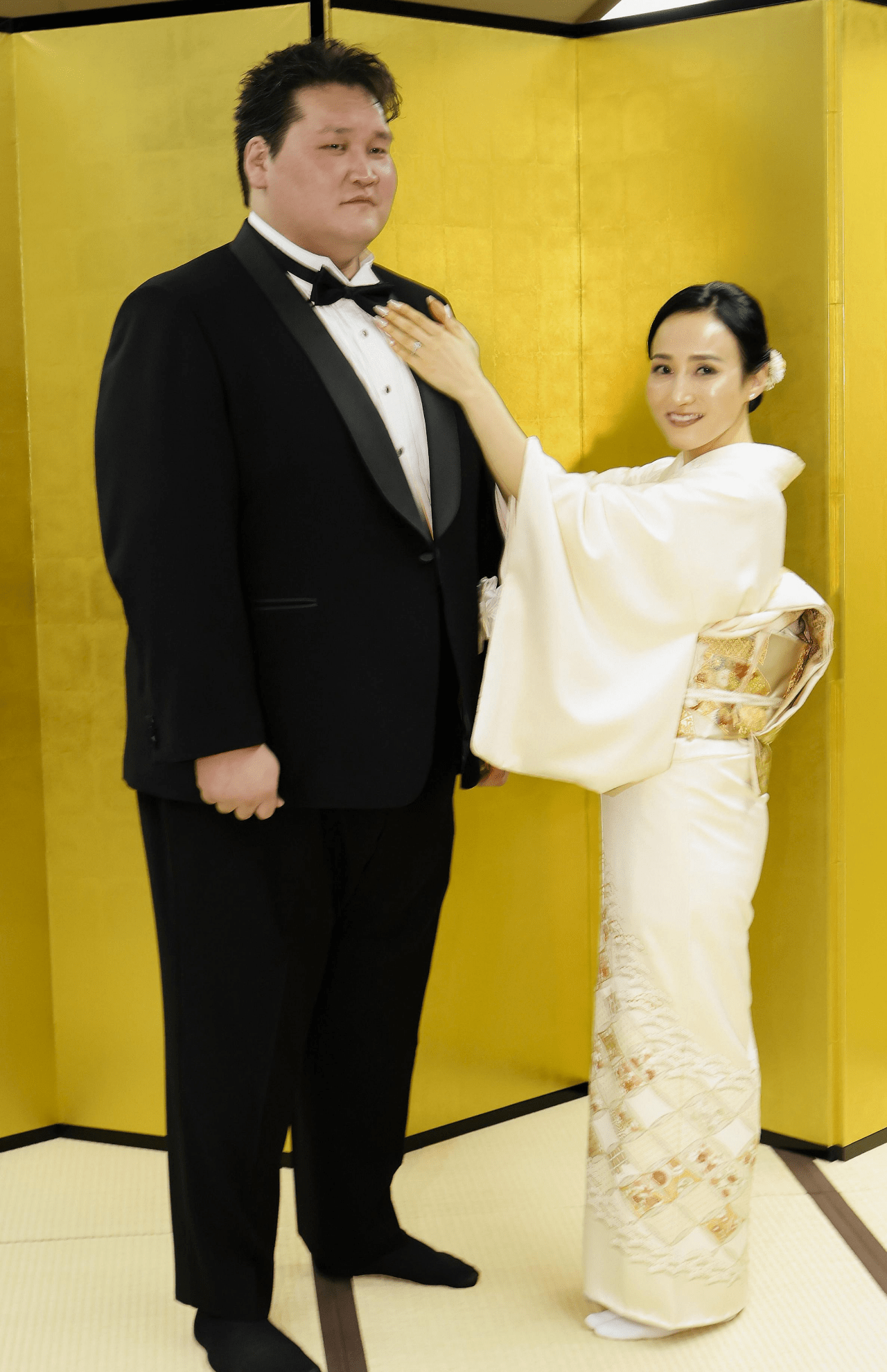 整髪を終え、妻のドルジハンドさんにネクタイを整えてもらう元横綱照ノ富士の伊勢ケ浜親方＝31日、東京・両国国技館（写真／共同通信）