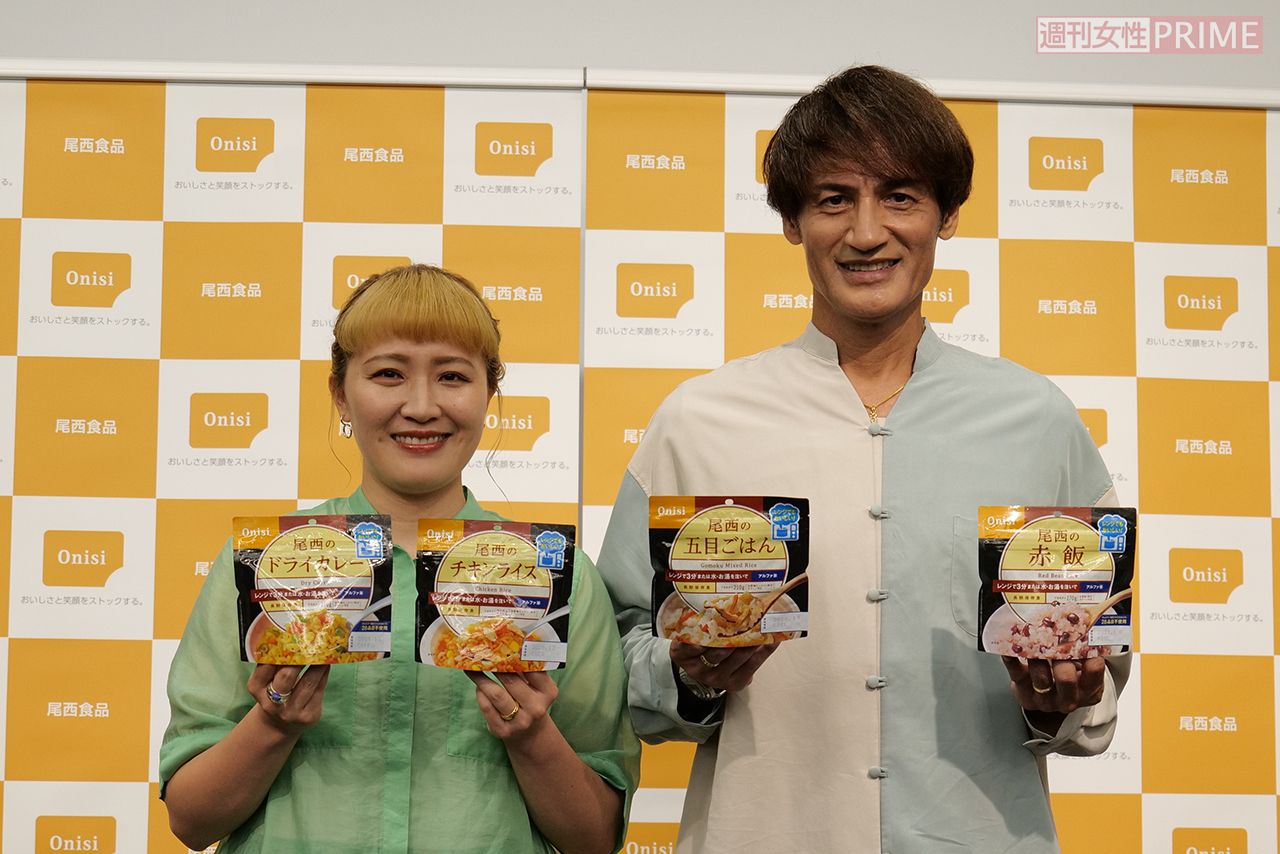 尾西食品株式会社の商品を手にして、笑顔の本並健治・丸山桂里奈夫妻