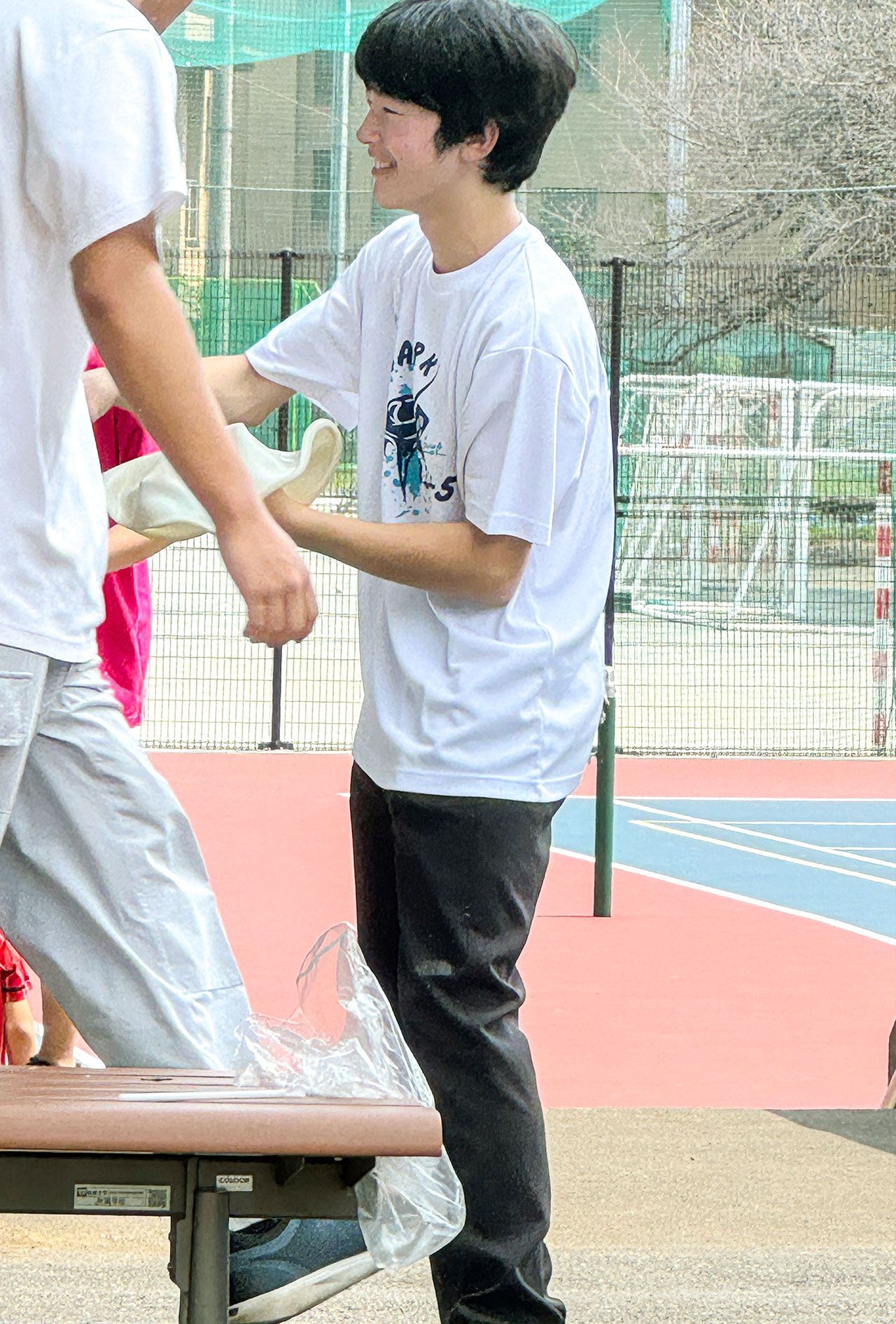 筑波大学附属高校の文化祭で、ご学友とピザ生地のようなものをくるくると回す悠仁さま（来場者提供）