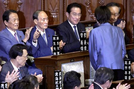 2025年10月21日、女性初の内閣総理大臣に任命された高市早苗。自民党の（奥左から）麻生太郎副総裁、菅義偉元首相、岸田文雄元首相らに向け頭を下げた（撮影／共同通信）