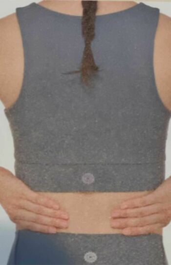 「腎のリンパケア」（1）人さし指、中指、薬指、小指が腎臓の位置（背中のウエストライン）に当たるように両手を置く