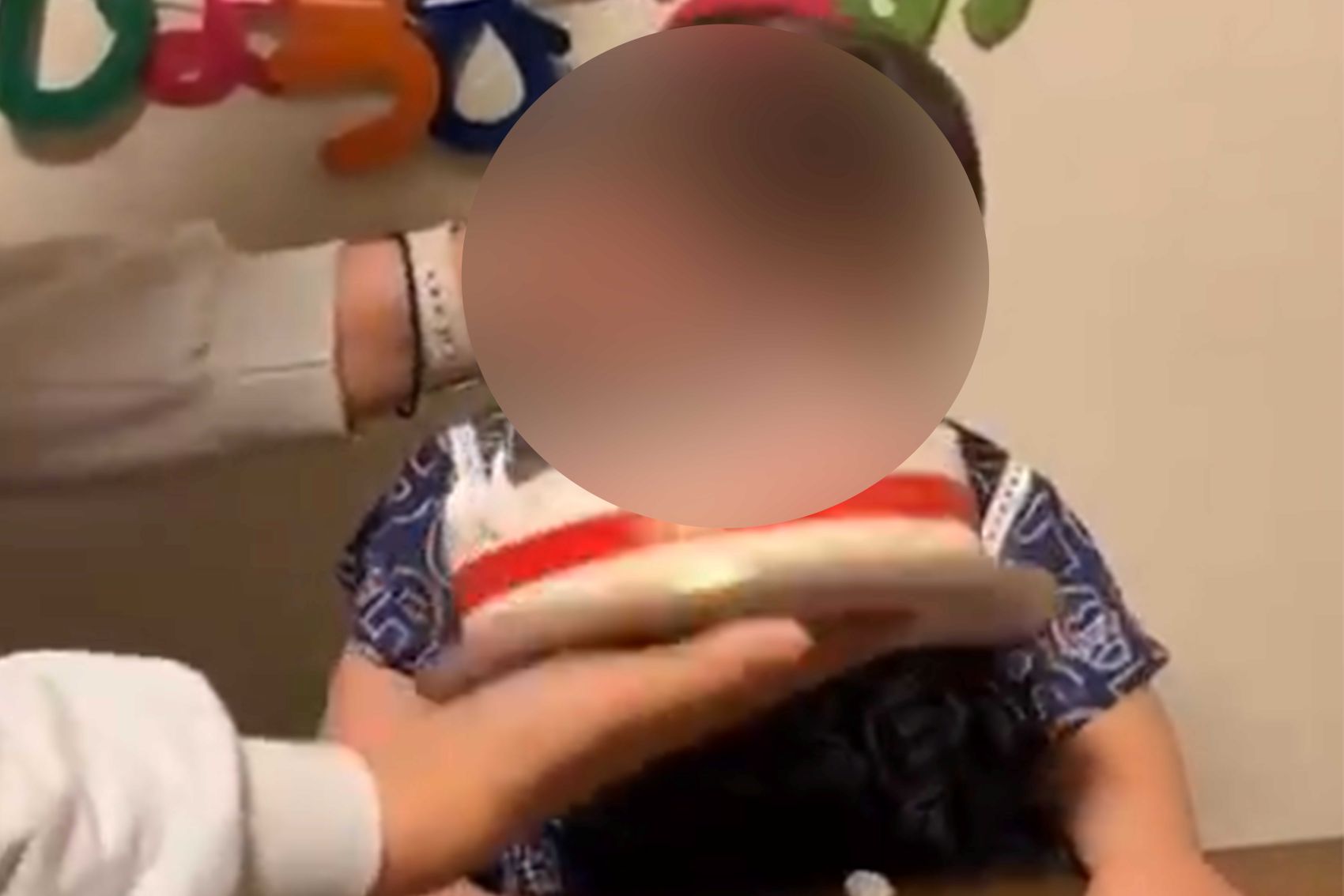 顔にケーキを押し付けられた幼児（拡散された動画より）