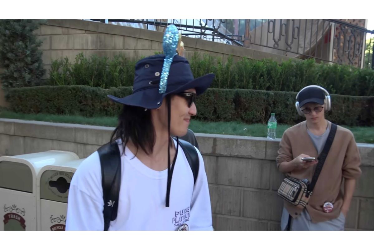 ディズニーでスマホを触りながらヘッドホンをして休憩する川島如恵留