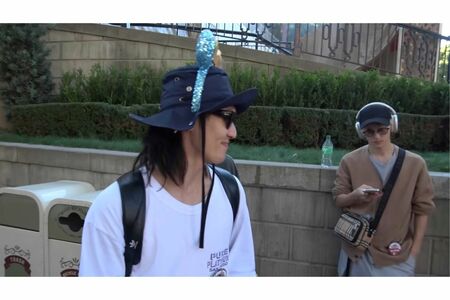 ディズニーでスマホを触りながらヘッドホンをして休憩する川島如恵留（Travise Japanの公式YouTubeチャンネルより）