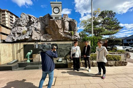 湯元の広場の時計台前にて。中央左から酒井さん、岩永洋昭さん、後上翔太さん