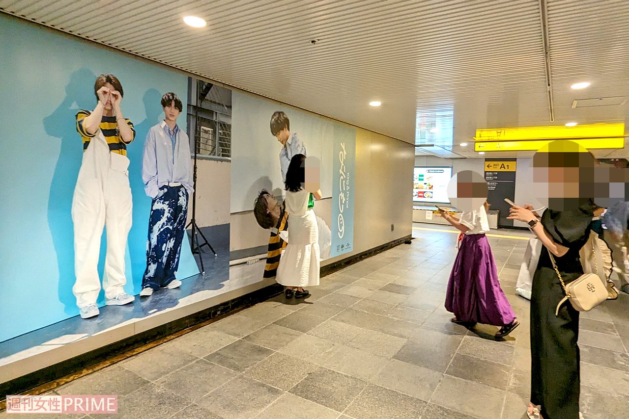 渋谷駅地下通路に展示されたKing & Prince『なにもの』巨大広告と記念撮影をするファン