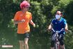 隣を自転車で走る坂本トレーナーと笑顔で顔を見合わせる兼近