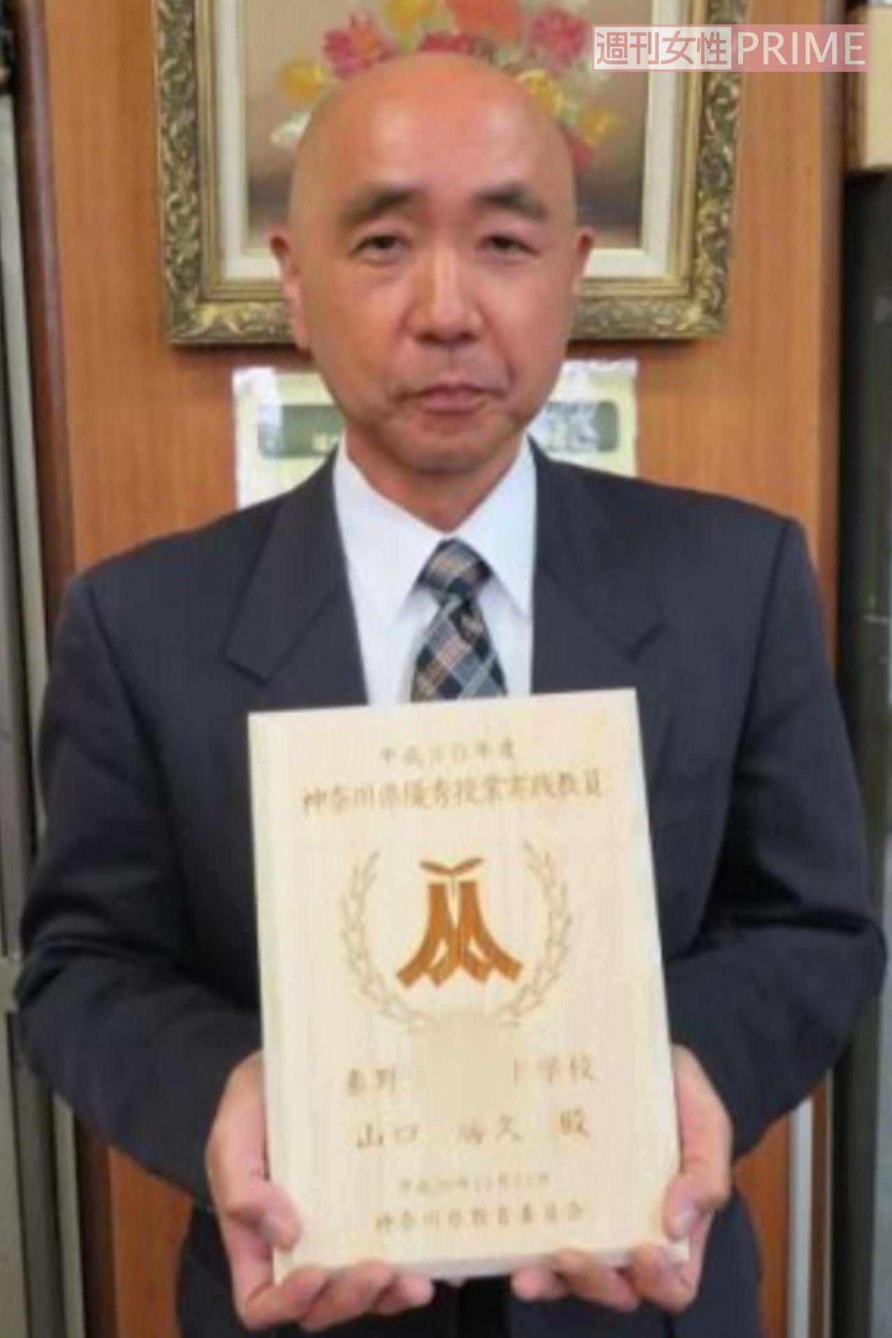 「優秀教師」の表彰状を持つ山口容疑者（勤務先だった中学校の資料より）